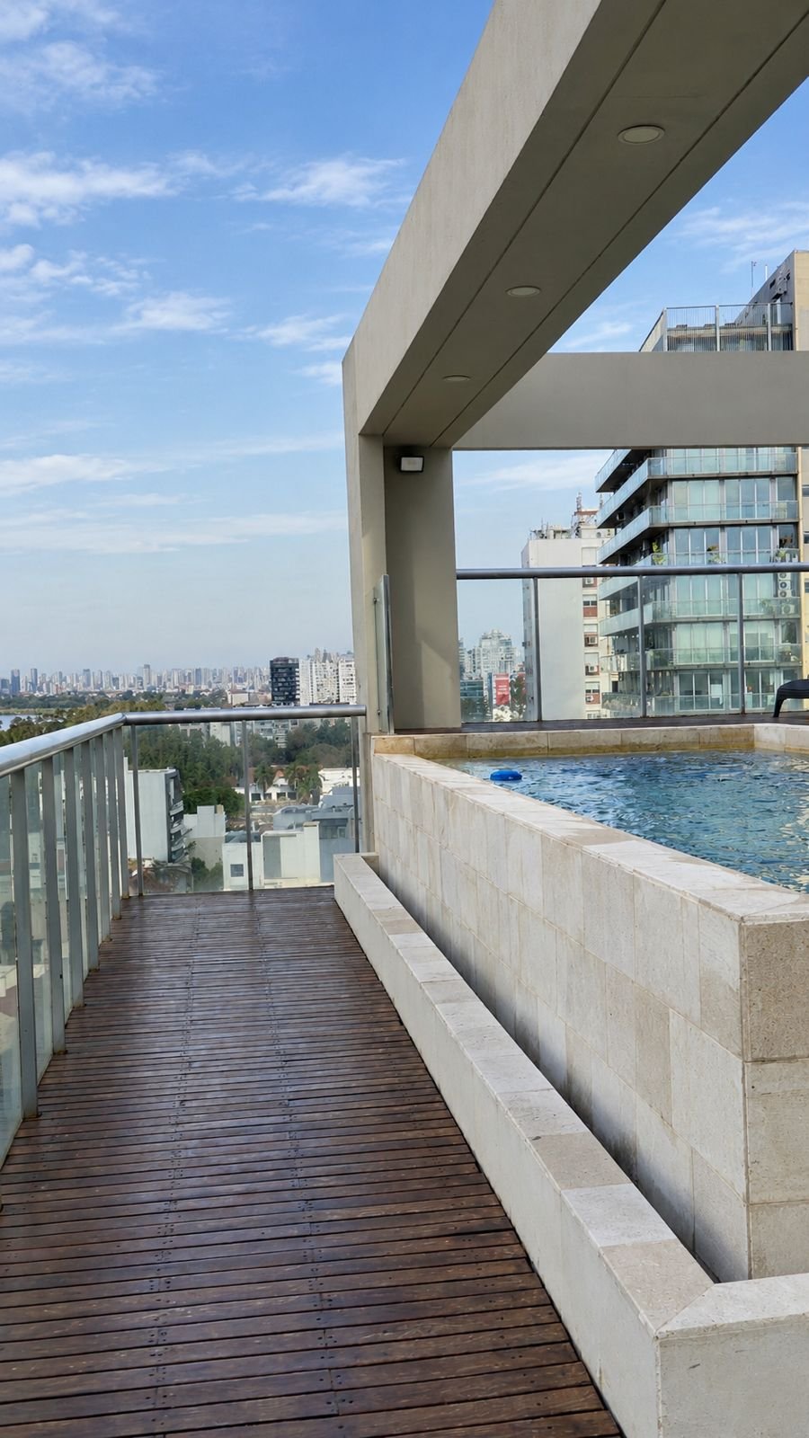 Solárium con deck y pileta en la terraza del edificio